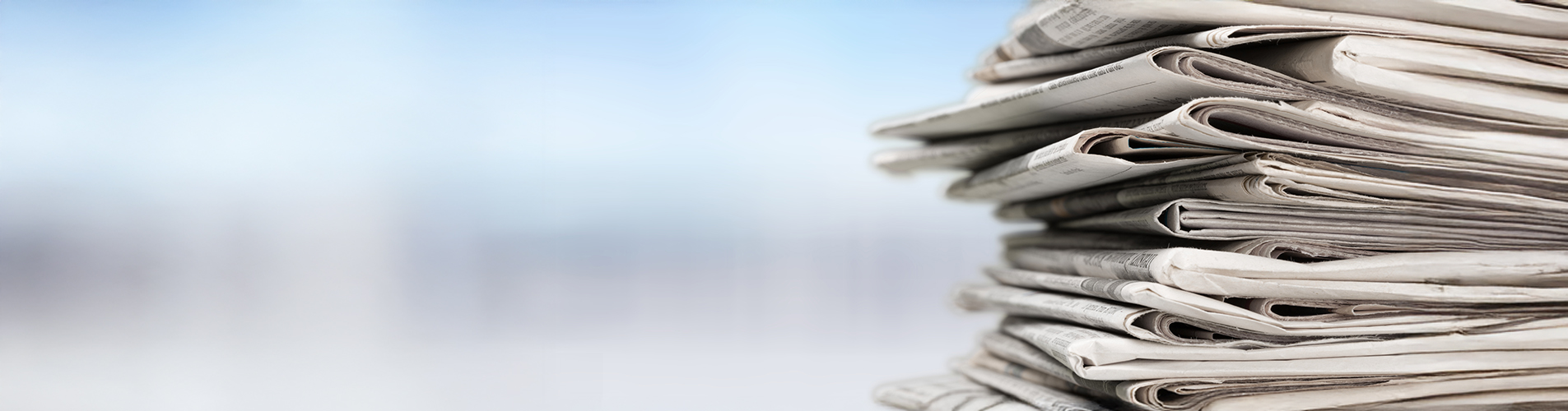 A stack of print media, showcasing various newspapers